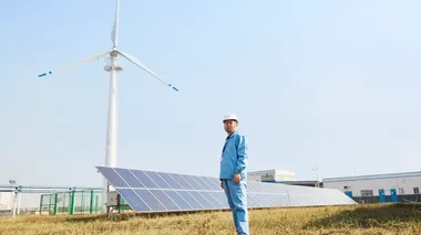 Hombre parado frente a los paneles solares